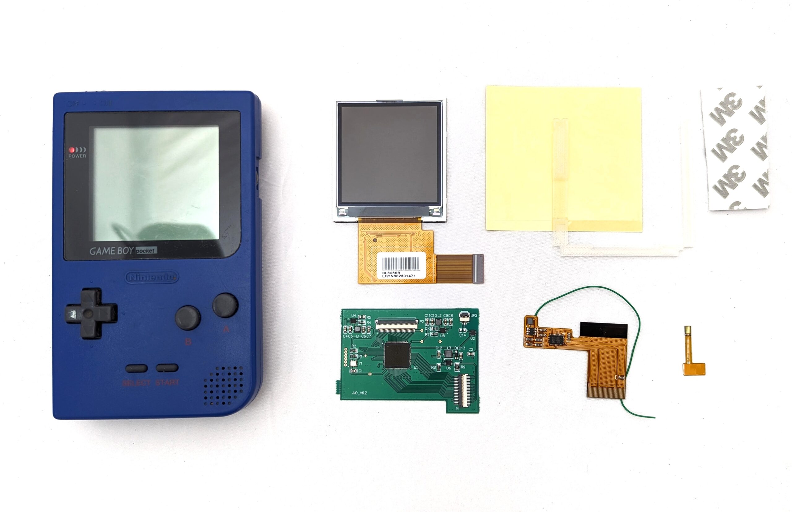 A blue game boy sits next to a collection of modding supplies, including materials and technical components.