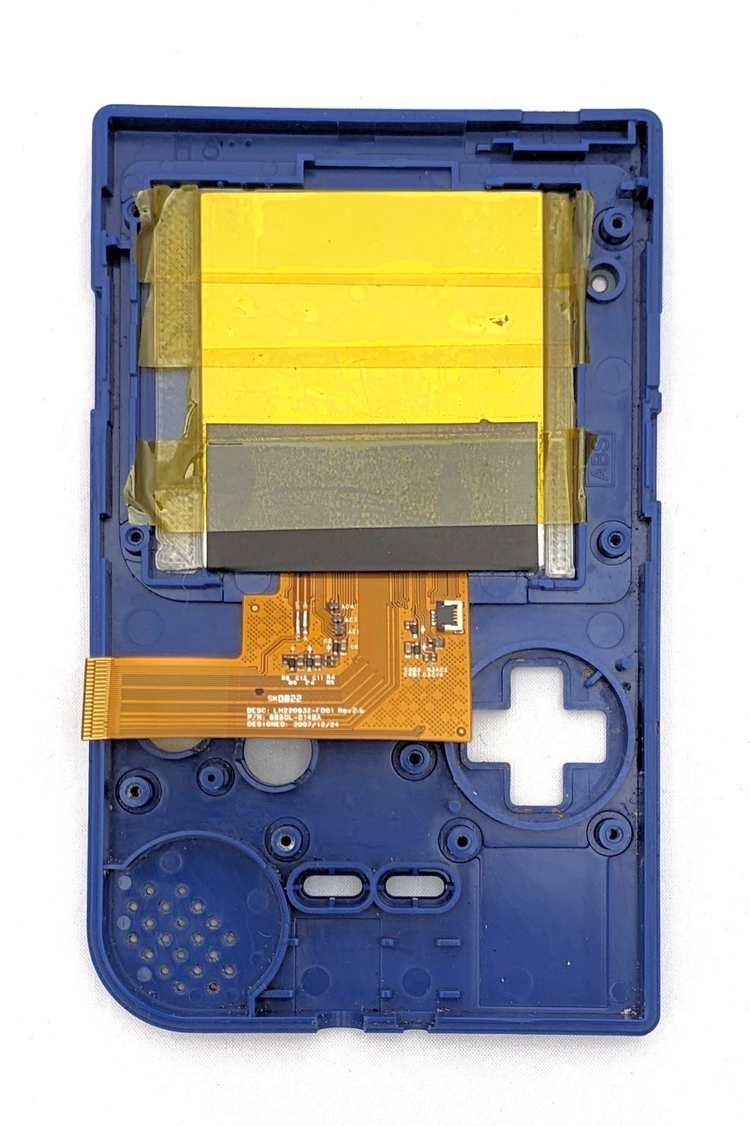 The inside shell of a game boy with a new screen implemented and covered with kapton tape