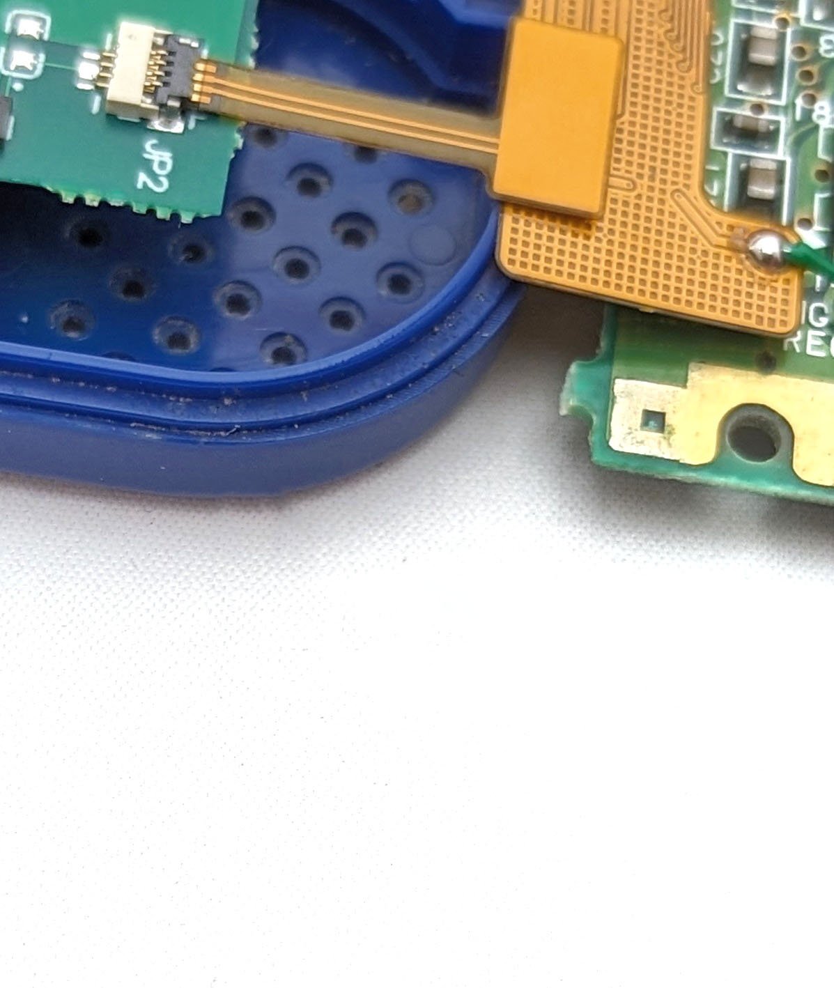 A close up on a ribbon cable plugged into a game boy