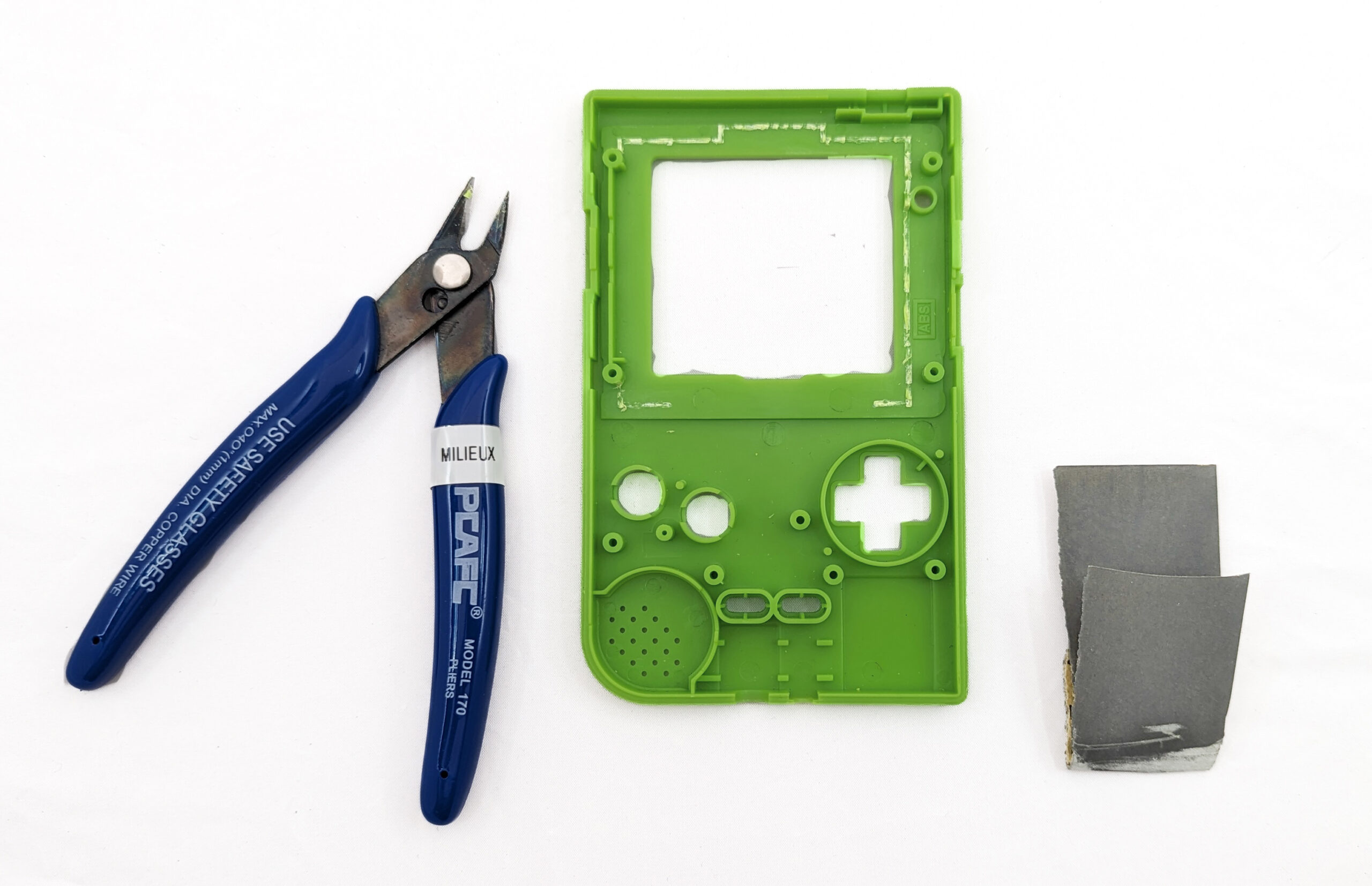 A green game boy shell next to a pair of flush cutters
