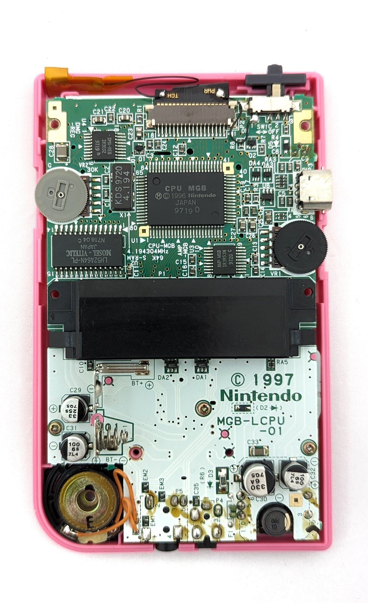 The inside of a game boy in a pink shell