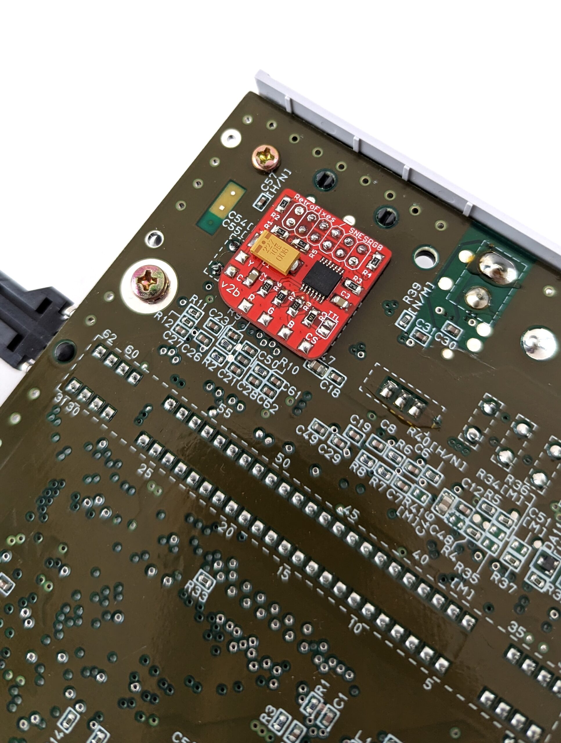 A red chip soldered onto the SNES's main PCB.
